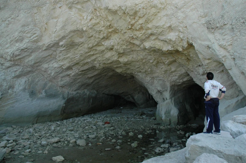 a person standing next to some rocks by a small stream