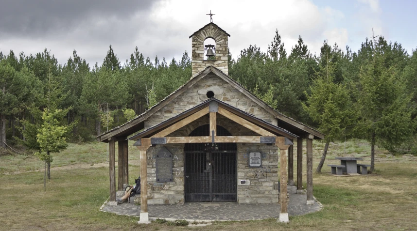 an old stone building with a bell on top of it