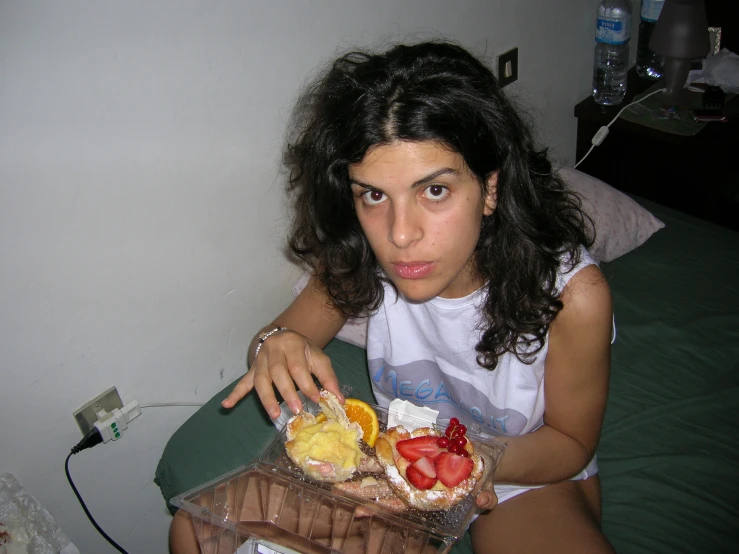 a woman sitting on a bed looking into the camera