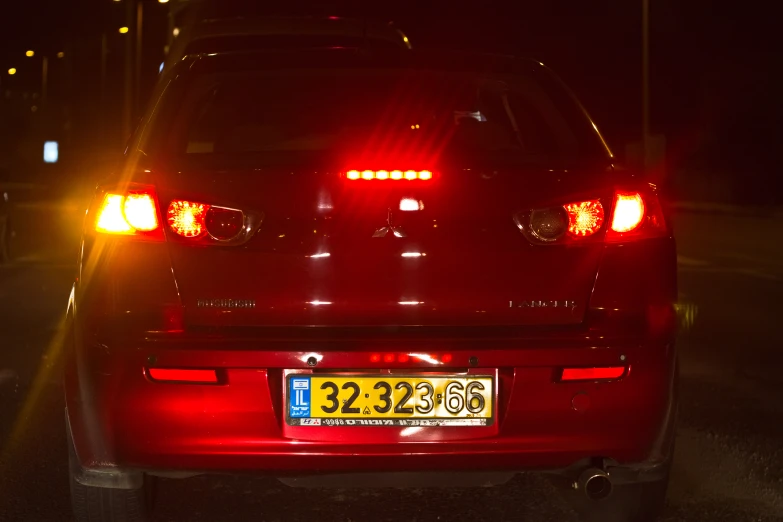 the back lights of a red sedan