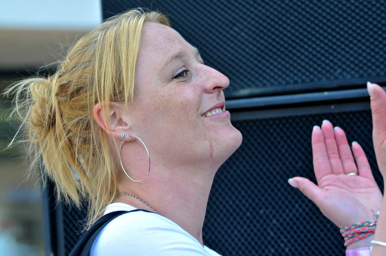 a woman that is talking and smiling in front of a sign