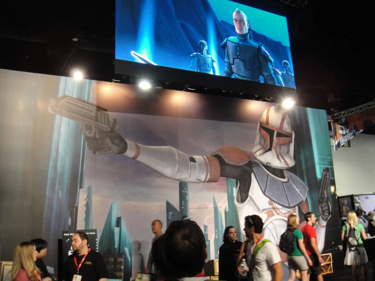 some people are standing around in front of a star wars banner
