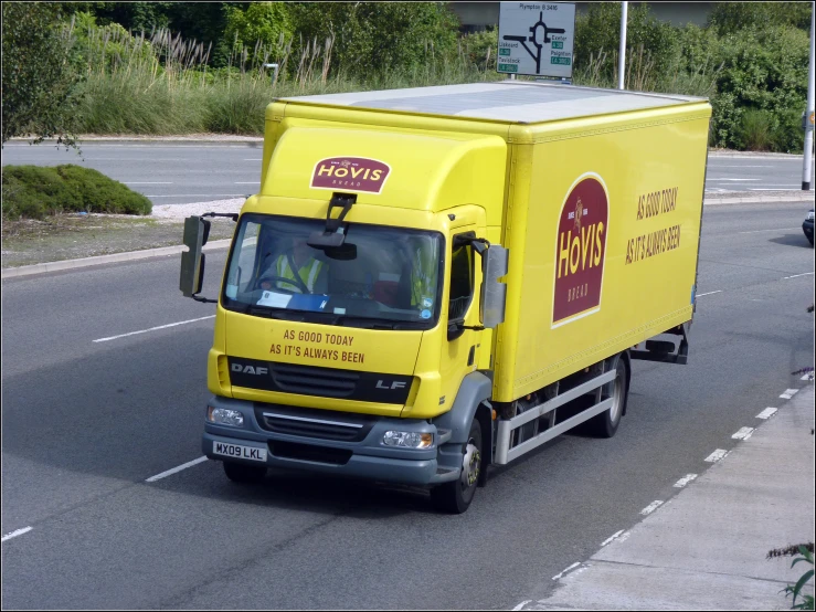 a yellow delivery truck on the side of the road