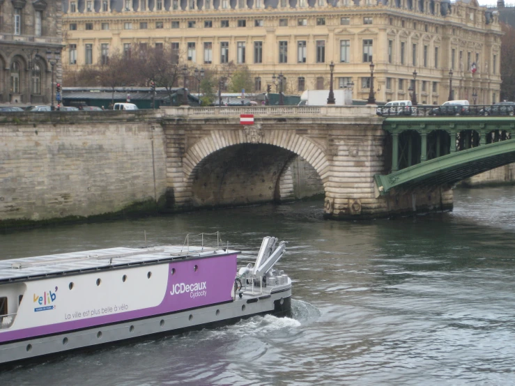 a barge floating on the river in front of a bridge