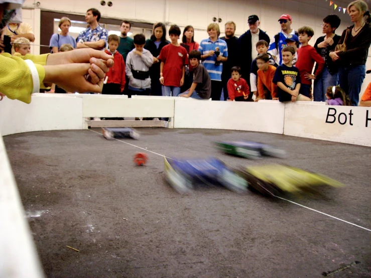 people watching small race cars go by in a miniature competition