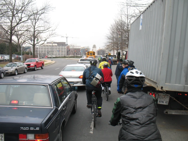 several bicyclists are riding down the street together