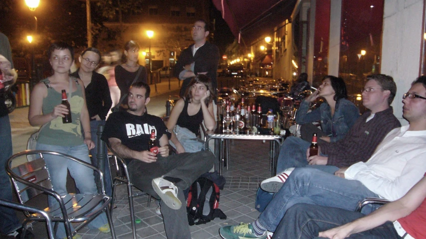 a group of people are sitting in chairs in the street