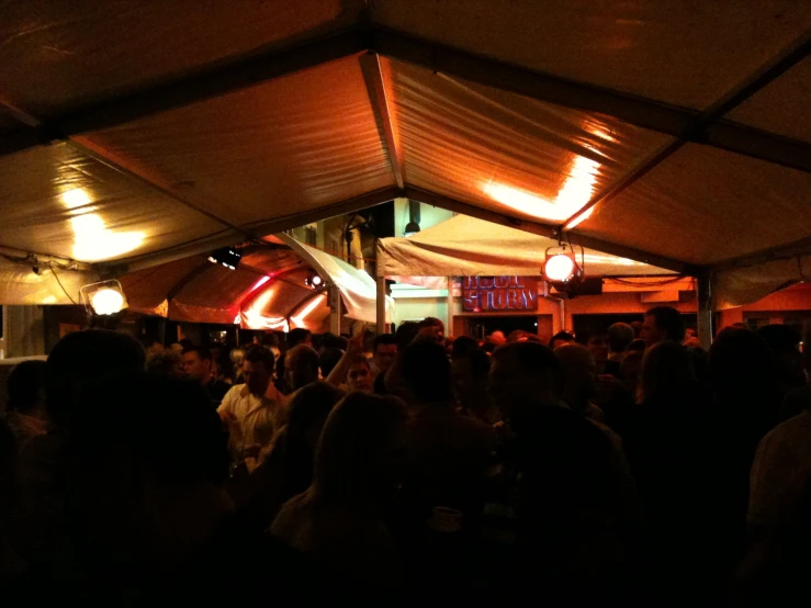 a crowded dance in a restaurant with lights on the ceiling