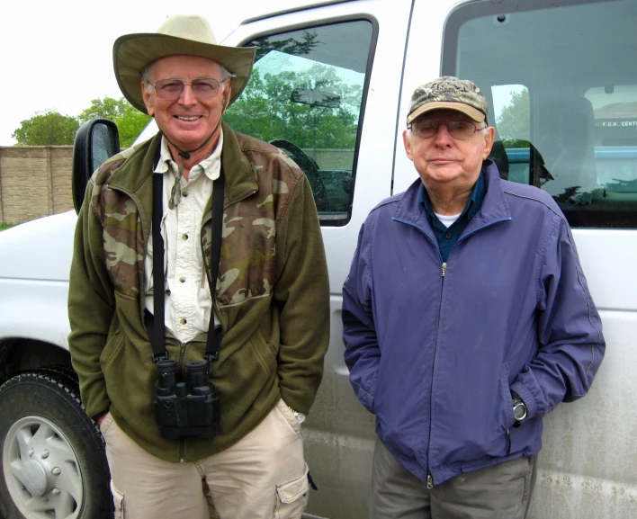 an older man is standing next to a younger man