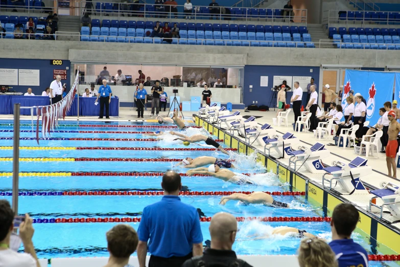 an indoor pool filled with people and lots of chairs