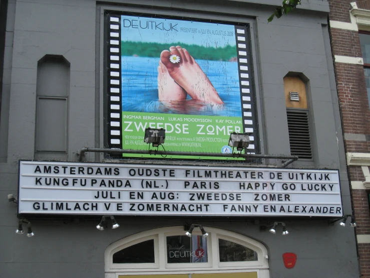 sign outside of theater in german language on grey building