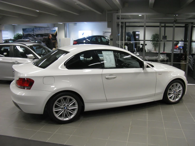 an image of a white car that is parked in the show room