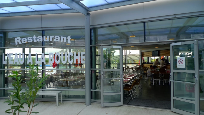 an outside restaurant with tables and chairs with glass doors