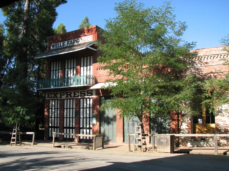 this old brick building is near a small fence and trees