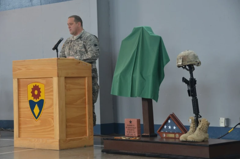 a man at a podium with several items on the table