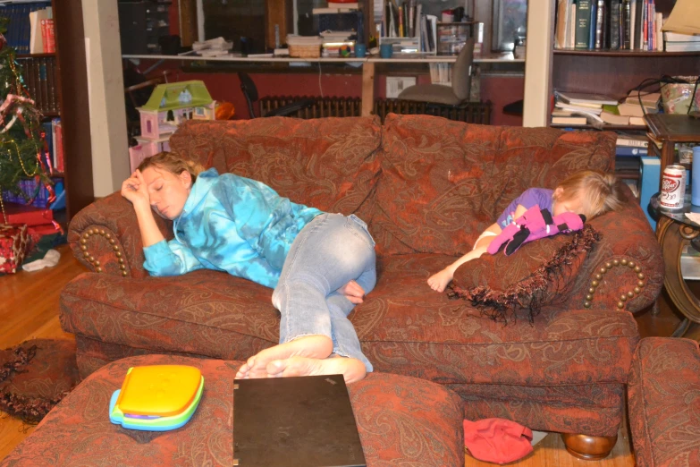 two children laying on a couch in the living room