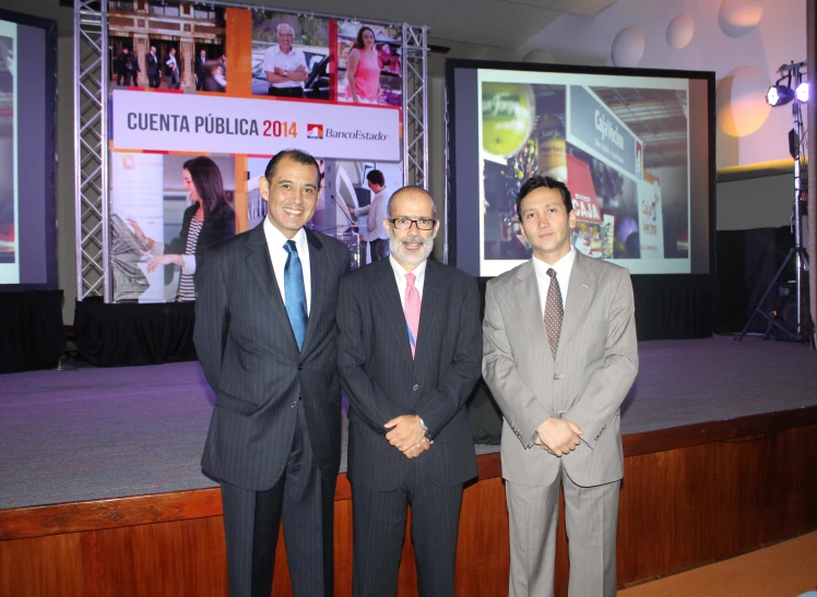 three men in business attire standing together at an event