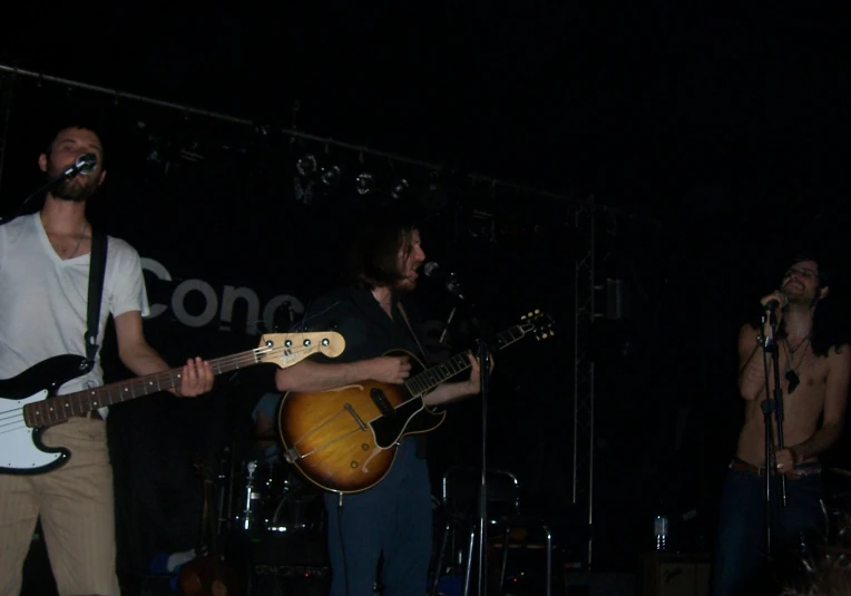 two men are playing guitar at a concert