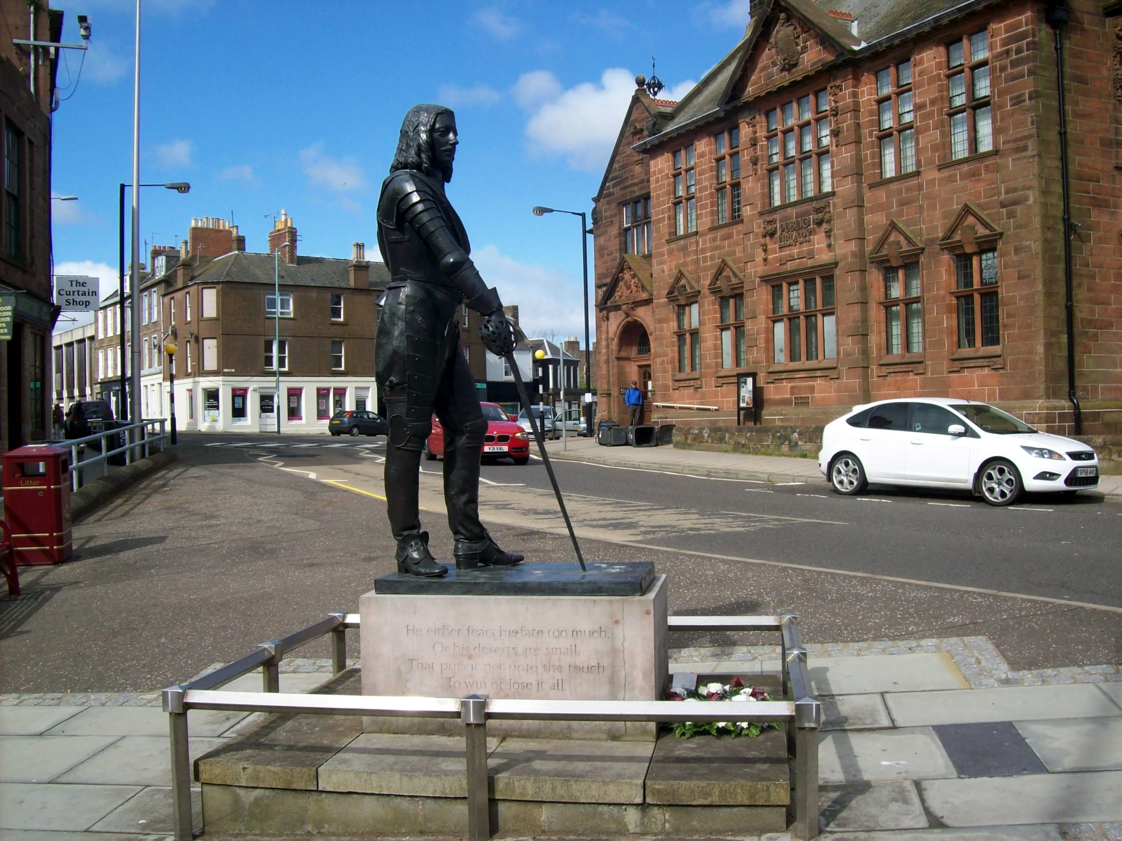 the statue of a man is next to some cars