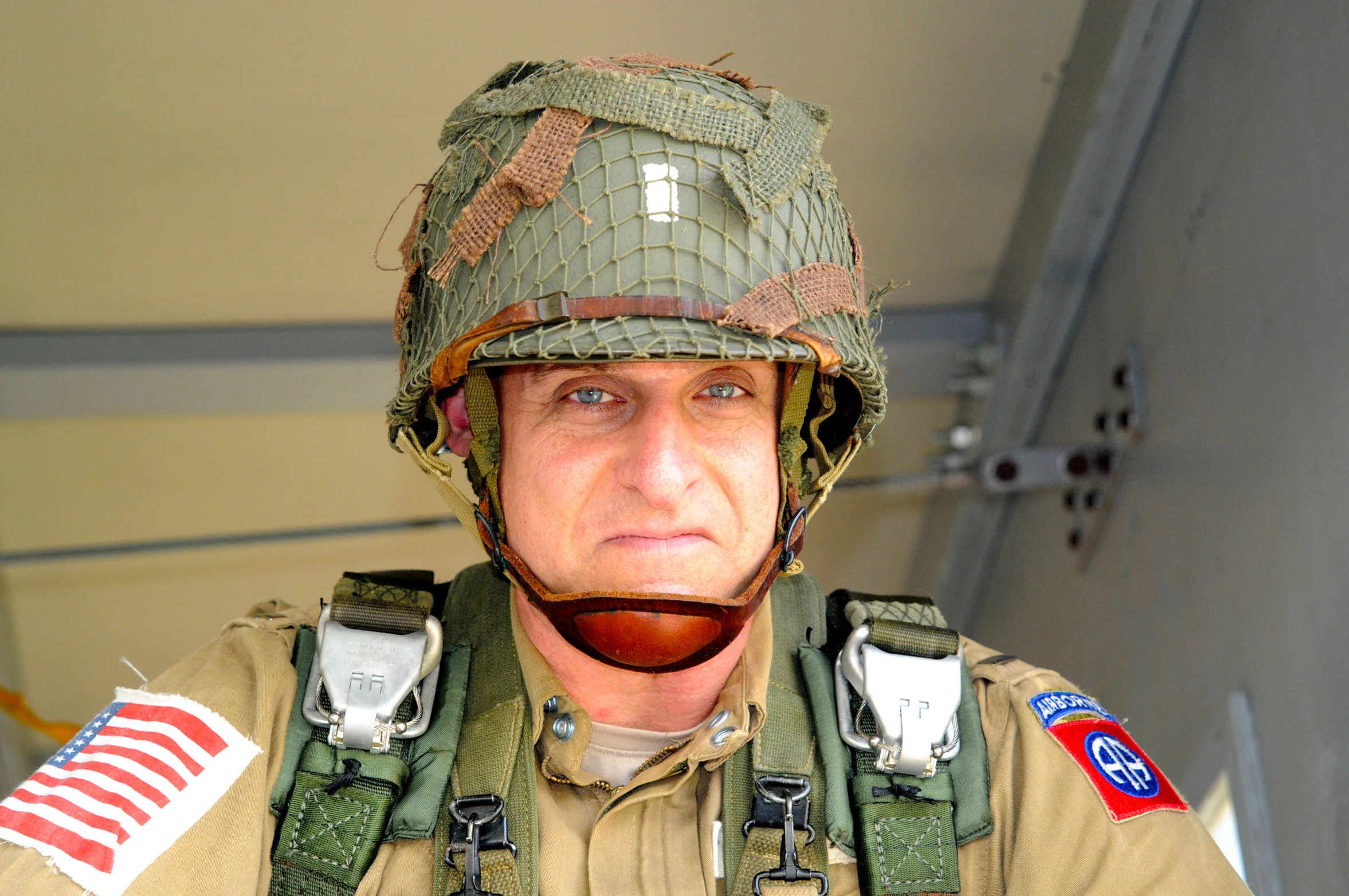 a soldier in camouflage is standing with a helmet on