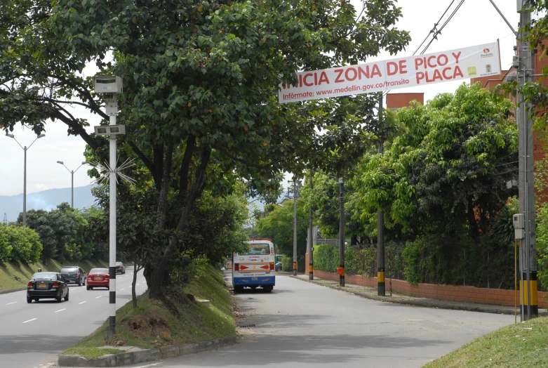 cars are on the side of a road and there is a street sign