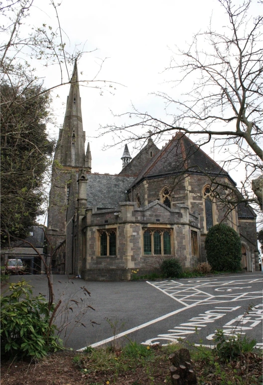 an old church building with two towers, next to some trees