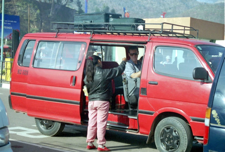 the woman has a bag in her hand while driving the van