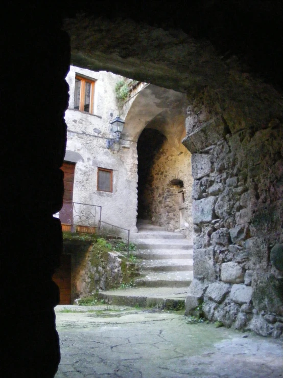 a view of a stone building through a tunnel