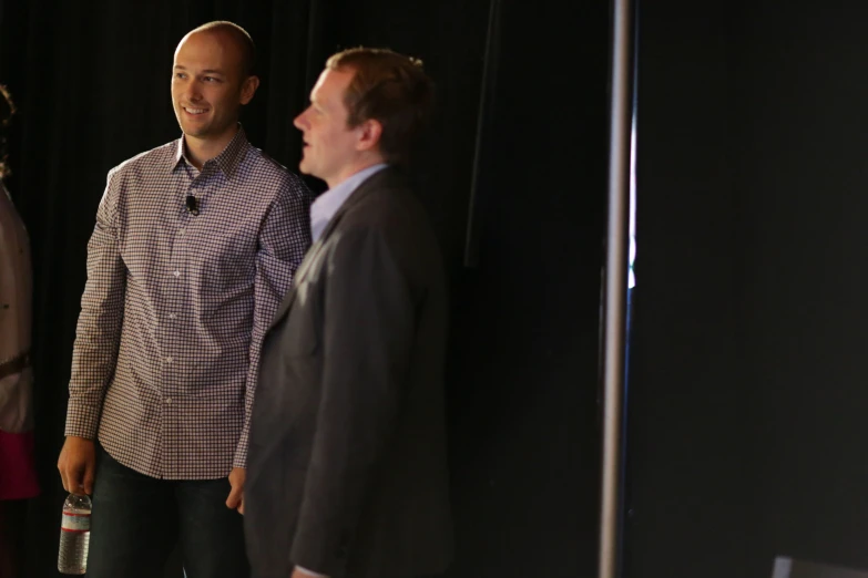 three men standing around and looking at one another