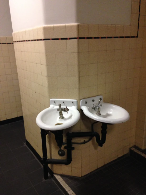 two small, white sinks sit on a black base