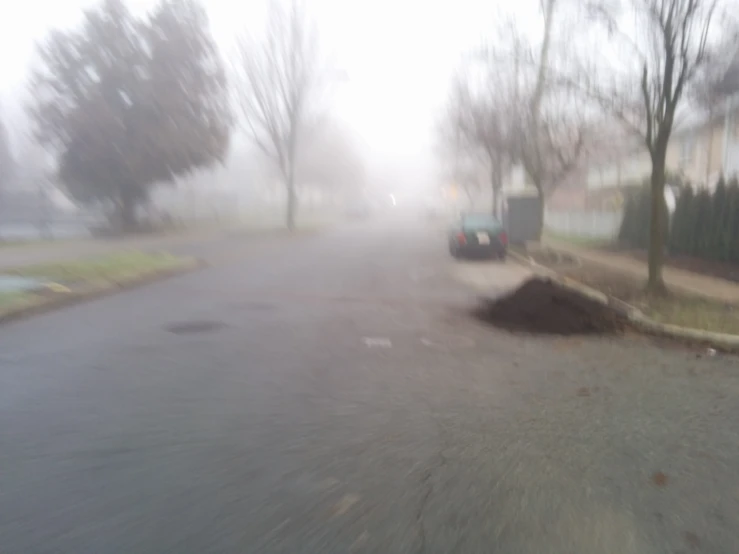 a foggy city street filled with lots of trees