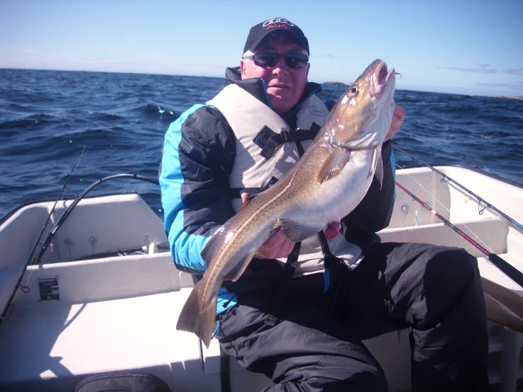 a man sits in a boat with a large fish