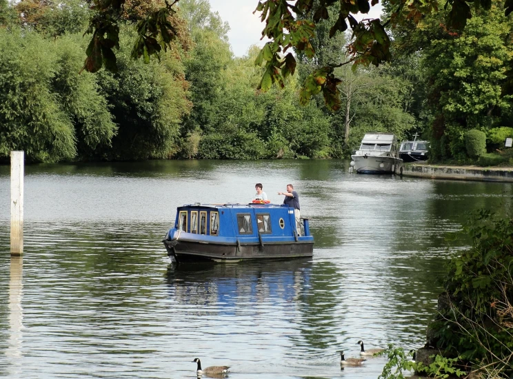 there is a blue boat that has two people on it