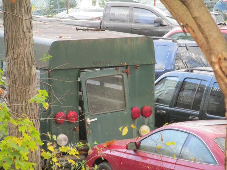 a small green cabinet sits between parked cars