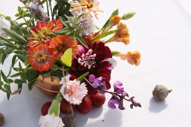 an assortment of flowers and eggs are on a white tablecloth