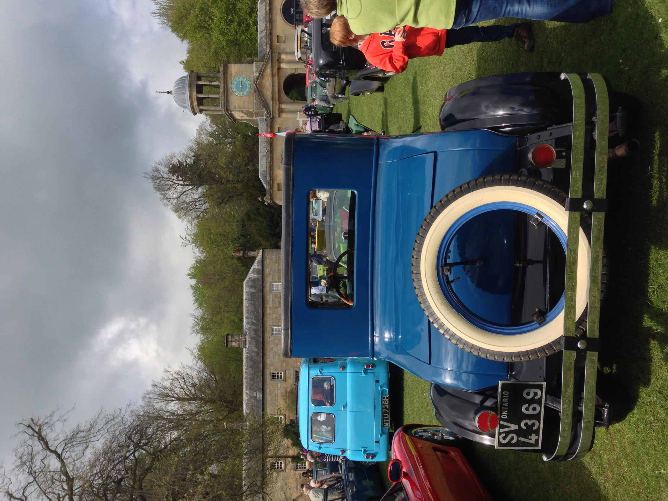 people looking at the antique blue truck on display