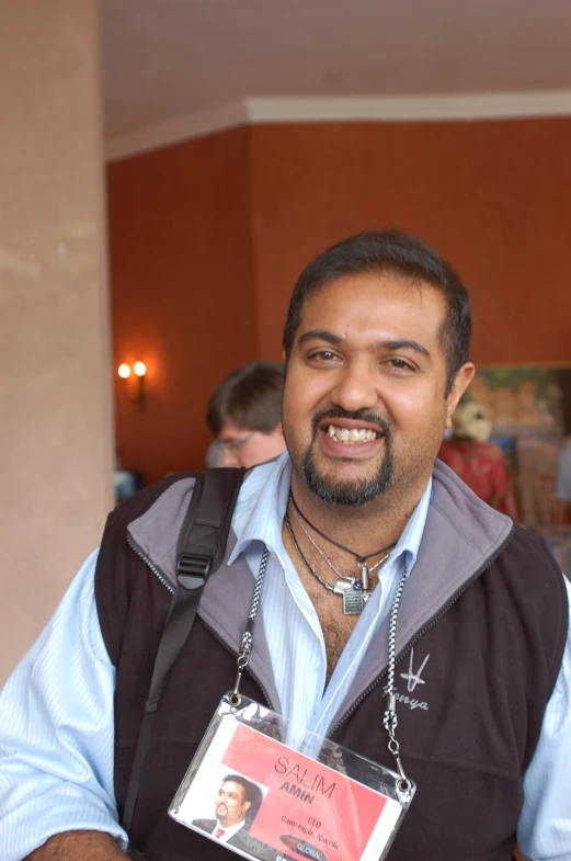 a man with a silver chain is smiling for the camera