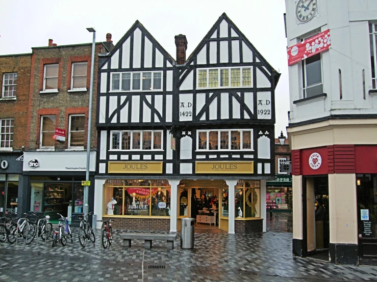 a street scene with buildings, bicycles, and shops