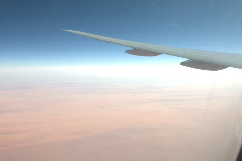 the wing of a plane flying over a city