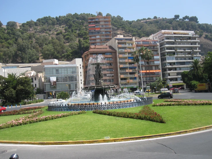 a city area has a fountain in the middle of it