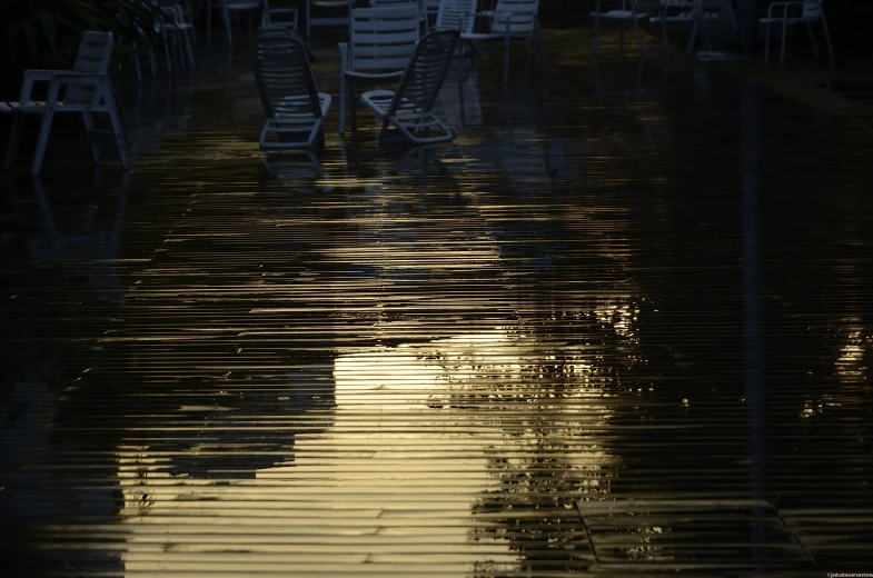 empty chairs sitting on the side of a flooded street