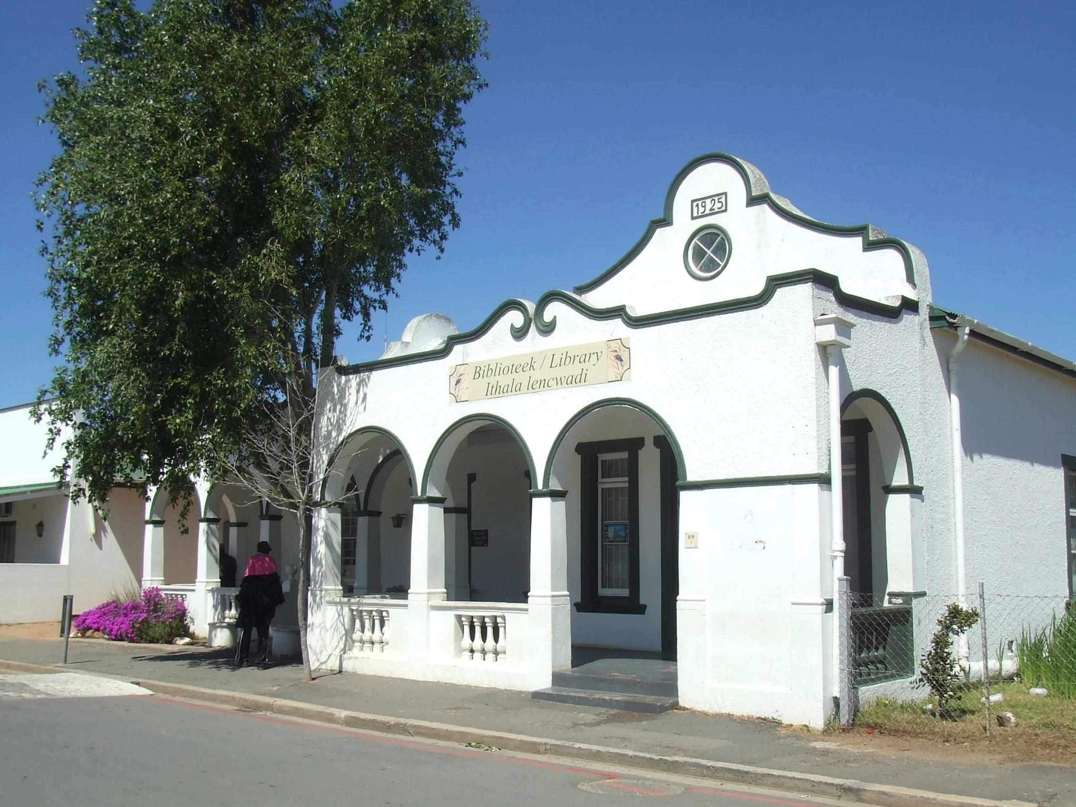 a woman is standing outside the white building