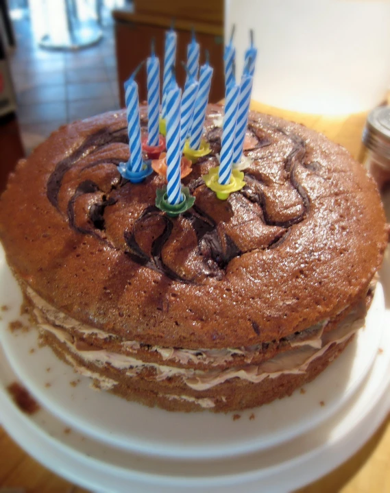 a cake with chocolate frosting and candles in the top