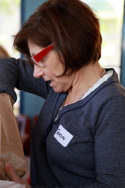 an older woman looking at soing that she is holding