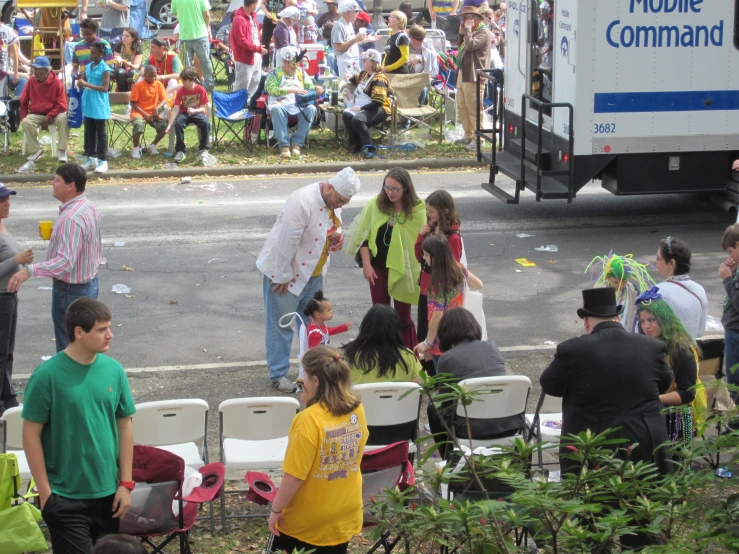 a crowd of people standing around a white truck