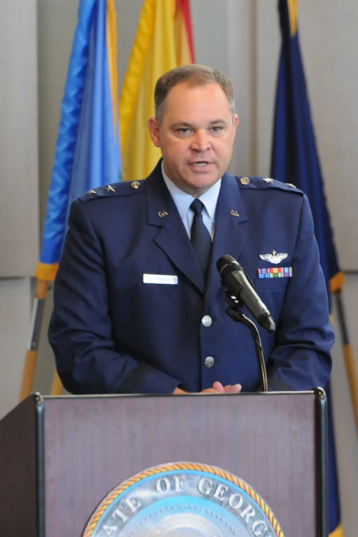 a military officer giving a speech from behind a podium