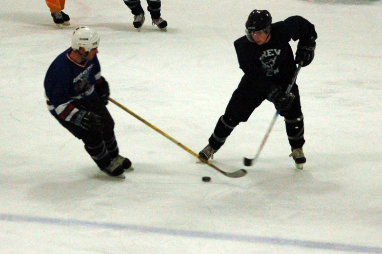 some ice hockey players are playing on an indoor rink