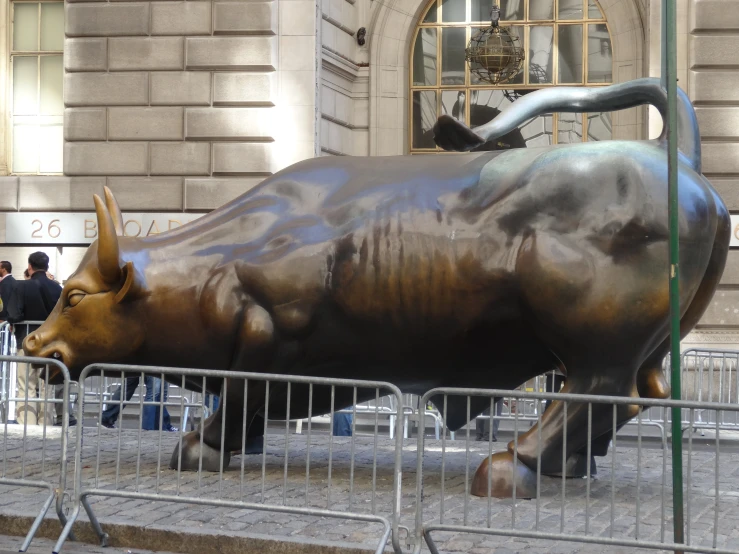 the statue of a bull is in the middle of the street