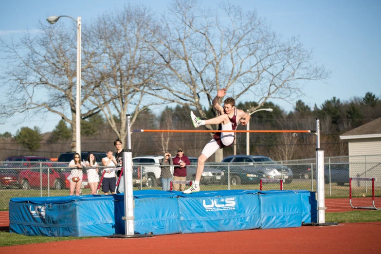 a man jumping over an obstacle with a racquet
