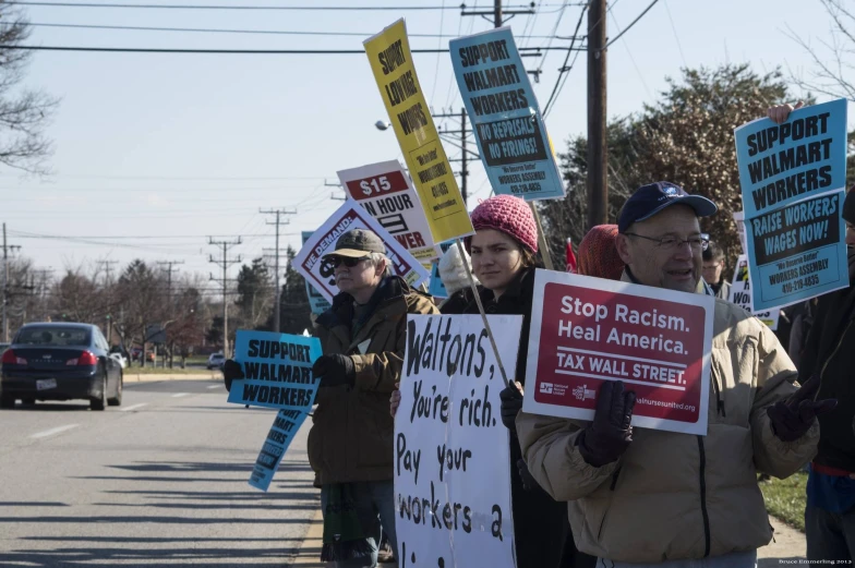 people on the side of the road holding signs